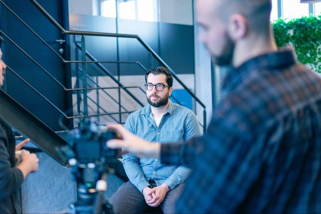 Opname van persoon voor video, contrast met AI-video zonder fysieke productie.