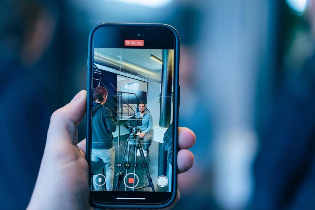 Smartphonescherm toont een lopende video-opname van een interview