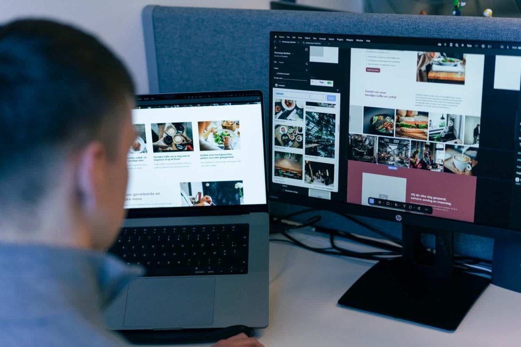 Conversal-specialist werkt aan het ontwerp van een systeem op laptop en extern scherm.