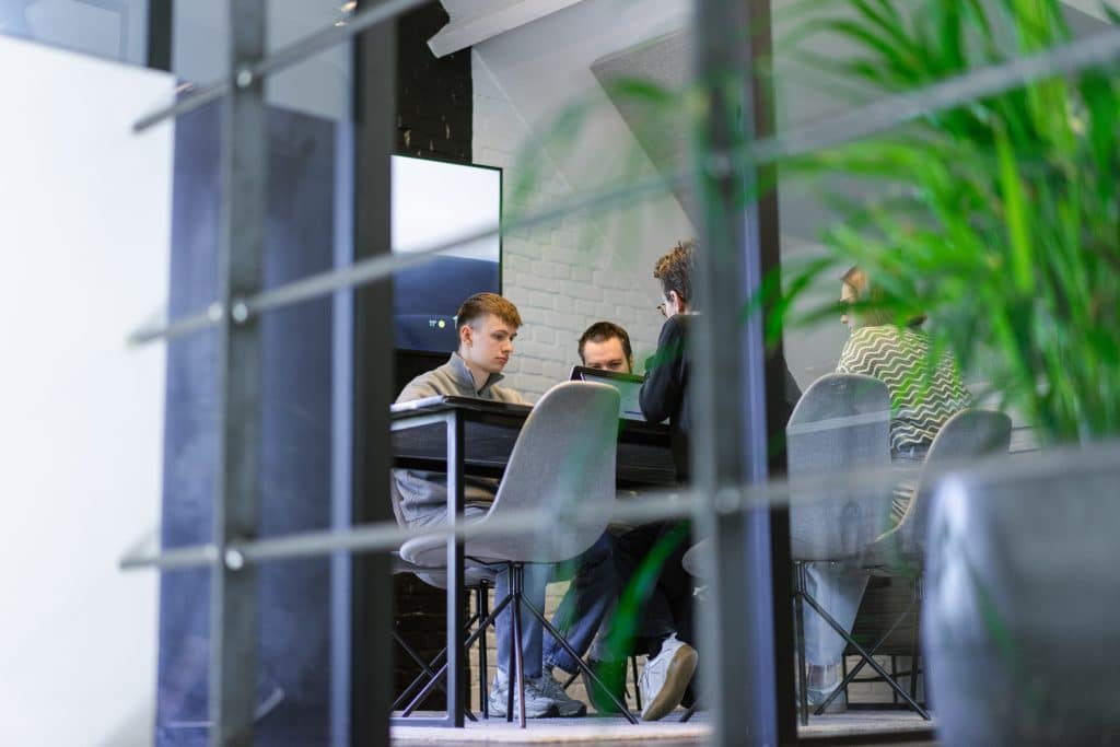 Het webteam van Conversal overlegt samen aan tafel over de opbouw van een WordPress website.